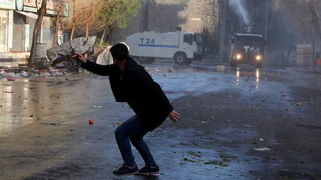 A man runs to take cover as Turkish riot police use a water cannon to disperse Kurdish demonstrators during a protest against a curfew in Sur district and security operations in the region, in the southeastern city of Diyarbakir, Turkey March 2, 2016 © Sertac Kayar