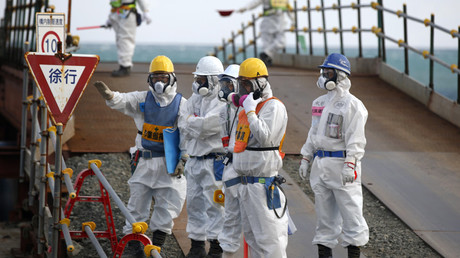 Workers, wearing protective suits and masks, are seen near the No. 3 and No.4 reactor buildings at Tokyo Electric Power Co's (TEPCO) tsunami-crippled Fukushima Daiichi nuclear power plant in Okuma town, Fukushima prefecture, Japan February 10, 2016. © Toru Hanai