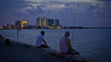 Men fish for red snapper along a causeway in Biscayne Bay at twilight in Miami © Carlo Allegri 