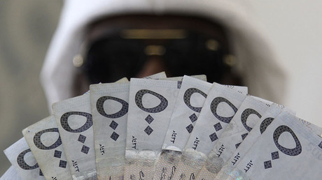 A Saudi man poses with Saudi riyal banknotes at a money exchange shop, in Riyadh, Saudi Arabia © Faisal Al Nasser