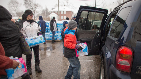 Volunteers load cases of free water into waiting vehicles at a water distribution centre at Salem Lutheran Church in Flint, Michigan, on March 5, 2016. © Geoff Robins 