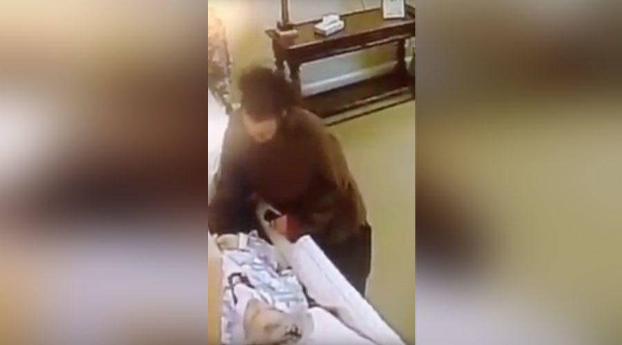 Dead wrong: Thief caught on camera stealing from corpse in casket