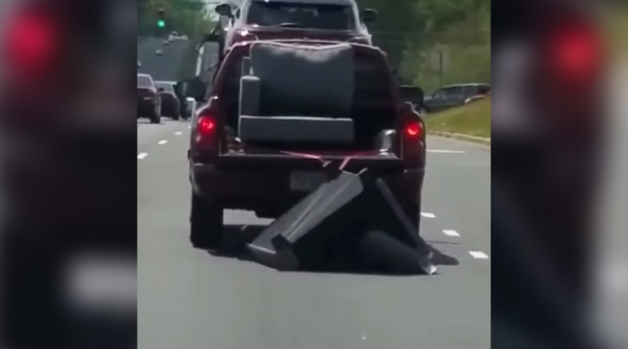 Clueless cops amazingly refuse to act as truck drags sofa along highway (VIDEO)