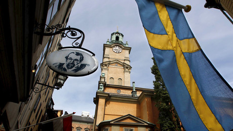 Sweden's flag waves near the Stockholm Cathedral in Gamla Stan or the Old Town district of Stockholm, Sweden © Bob Strong