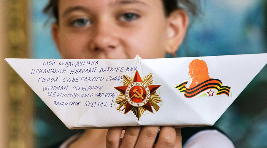 Katya Kimpinskaya, fifth grade student at Magnet School 5 in Feodosiya, who initiated the Ship of Victory, demonstrates her paper ship devoted to the memory of Nikolai Prilutsky, her gradfather and Hero of the Soviet Union. © Sergey Malgavko