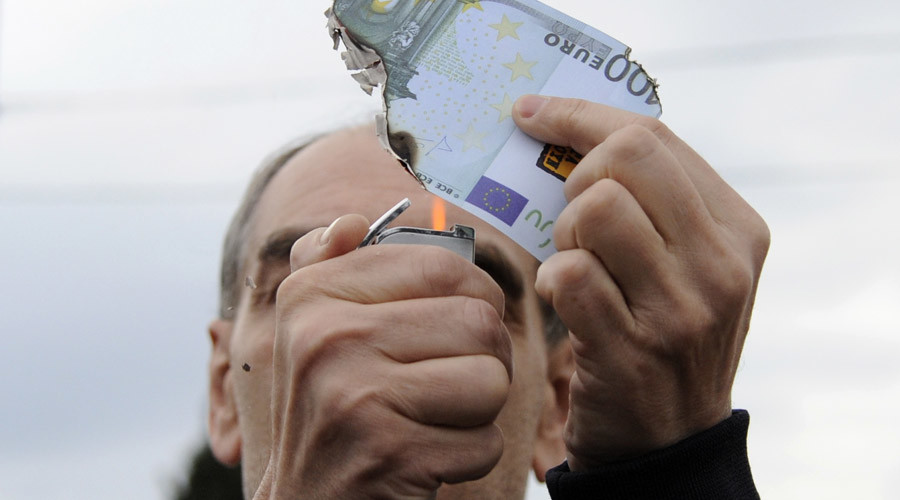A protester burns a fake one hundred Euro banknote during a demonstration against a new package of tax hikes and reforms in Athens, Greece, May 22, 2016 © Michalis Karagiannis