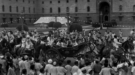 In this handout picture taken 15 August 1947, British Governor-General Lord Mountbatten (C) gestures as he rides in a carriage alongside Lady Edwina Mountbatten prior to witnessing the raising of the Indian tricolour for the first time at India Gate in New Delhi. © AFP