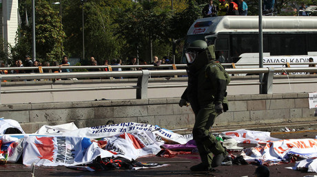 File photo: A bomb-disposal expert walks near victims' bodies covered with banners and flags, at the site of twin explosions near the main train station in Turkey's capital Ankara, on October 10, 2015. © Adem Altan