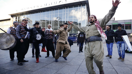 Migrants dance in front of the railway station during the 