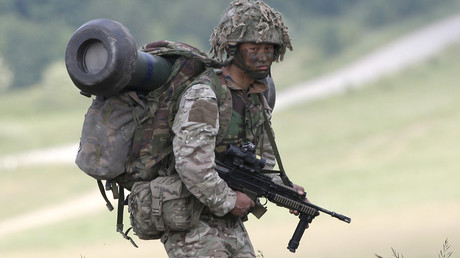 A British soldier on exercise walks across an area of Salisbury Plain, near to Westdown Camp, Britain © Peter Nicholls 
