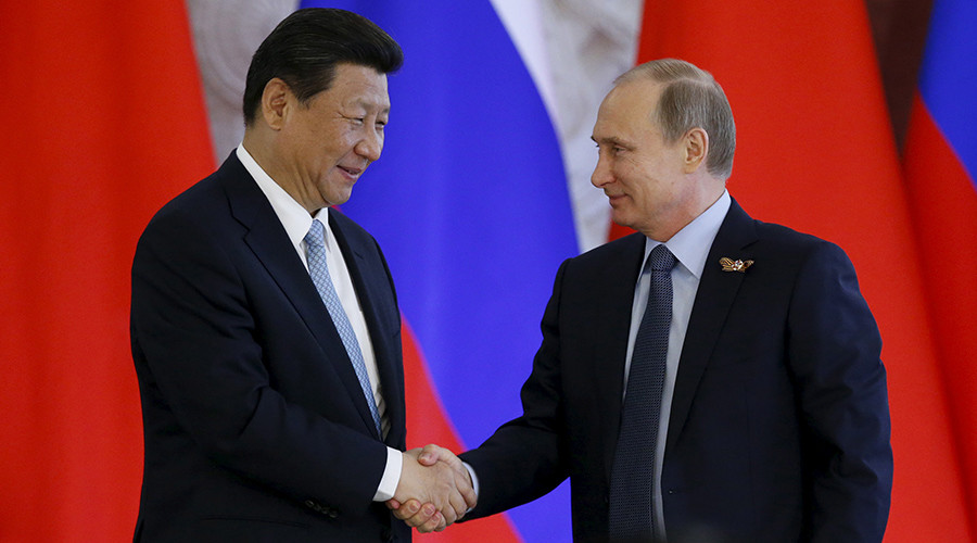 Russia's President Vladimir Putin (R) shakes hands with China's President Xi Jinping © Sergey Karpukhin