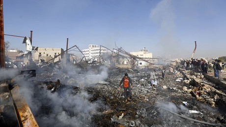 People walk on the rubble of an electronics warehouse store after a Saudi-led air strike destroyed it in Yemen's capital Sanaa February 14, 2016. © Khaled Abdullah