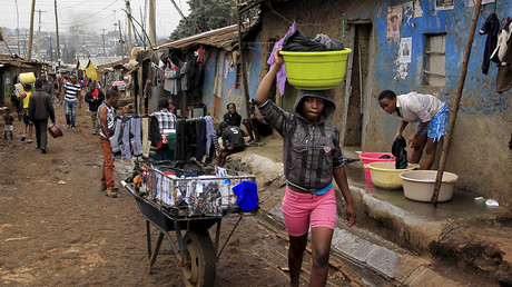 Young girls do laundry outside their house early morning in Nairobi's Kibera slums. © Noor Khamis