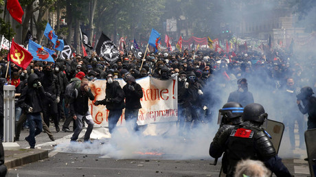 Masked youths with labour union flags are seen during clashes with French gendarmes and riot police during a demonstration in Paris as part of nationwide protests against plans to reform French labour laws, France, June 14, 2016. © Jacky Naegelen