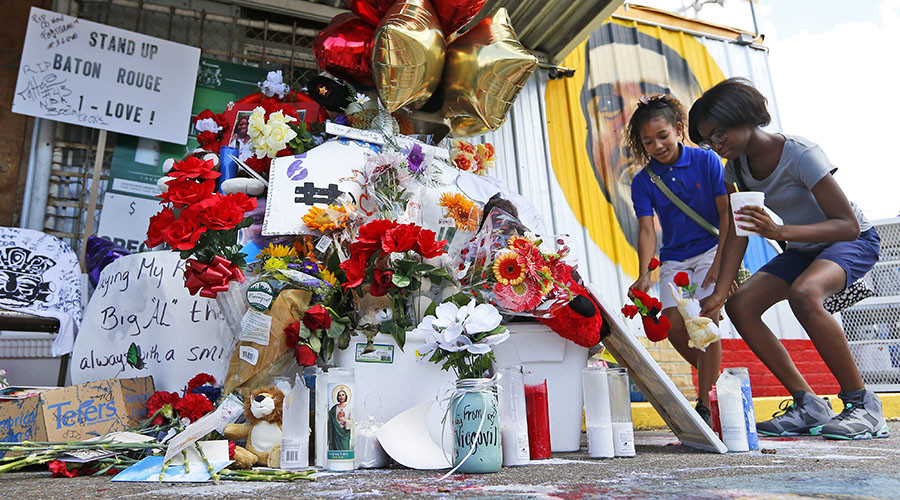 Savannah Greene (L), 11, and Alexis Marshall, 13, leave flowers at a makeshift memorial outside the Triple S Food Mart where Alton Sterling was fatally shot by police in Baton Rouge, Louisiana, U.S. July 7, 2016. © Jonathan Bachman