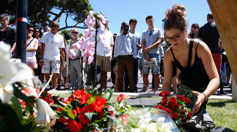 A woman places flowers a near the scene where a truck ran into a crowd who were celebrating the Bastille Day holiday. © Pascal Rossignol