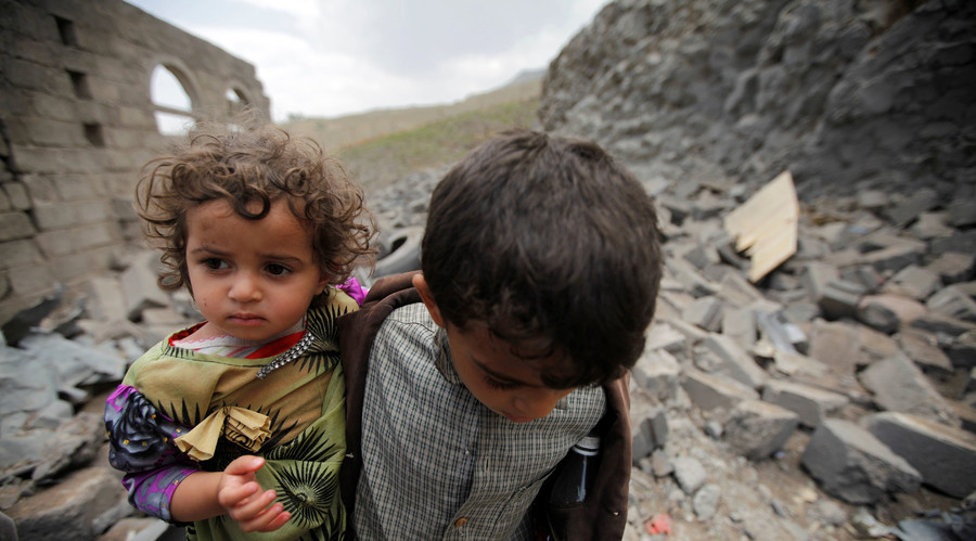 A boy carries his sister, as he walks on rubble of a house after it was destroyed by a Saudi-led air strike in Yemen's capital Sanaa, August 11, 2016. © Mohamed al-Sayaghi