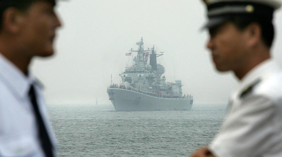 Chinese Navy officers wait dockside as a Chinese Navy warship escorting the arrival of the USS Curtis Wilbur (DDG54), a US Navy AEGIS class guided missile destroyer, arrives at Qingdao port, Qingdao, in eastern China's Shandong province. File photo. © Frederic J. Brown