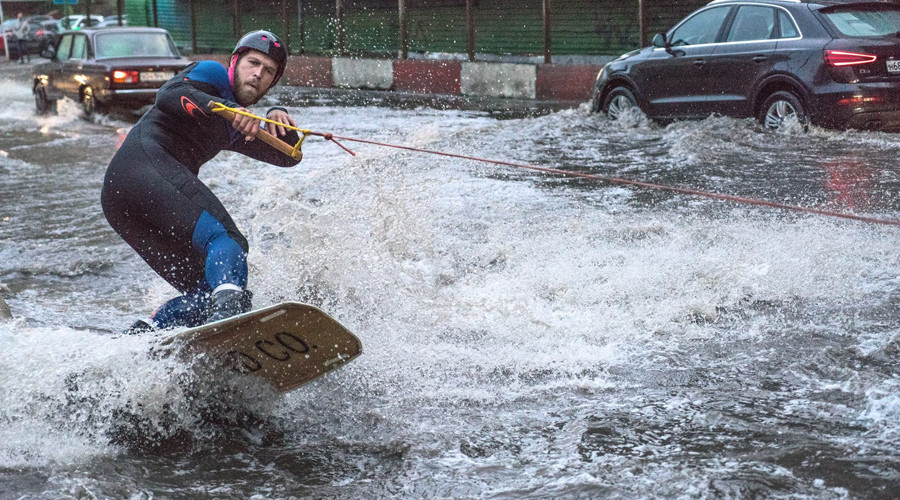 Watch man surf giant puddle on Moscow’s rainiest day ever (VIDEO)