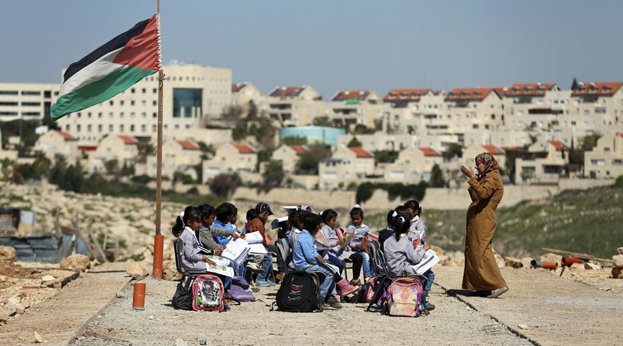 A teacher gives a class to Palestinian bedouin students outdoors near the Jewish settlement of Maale Adumim, in the West Bank village of Al-Eizariya, east of Jerusalem © Ammar Awad 