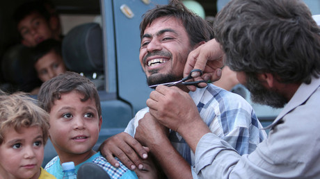 A man cuts the beard of a civilian who was evacuated with others by the Syria Democratic Forces (SDF) fighters from an Islamic State-controlled neighbourhood of Manbij, in Aleppo Governorate, Syria, August 12, 2016. © Rodi Said