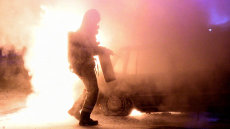 A firefighter attempts to extinguish a fire which had damaged cars after the vehicles had been set alight, in Malmo, Sweden, August 15, 2016. © Johan Nilsson
