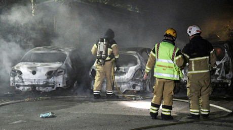 Firefighters extinguish a fire which had damaged cars after the vehicles had been set alight, in Malmo, Sweden © Johan Nilsson