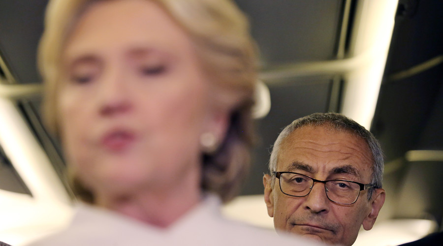 John Podesta, chairman of U.S. Democrat Hillary Clinton's presidential campaign, listens as she talks to the media inside of her campaign plane after the third and final 2016 presidential campaign debate in North Las Vegas, Nevada, U.S., October 19, 2016. © Carlos Barria