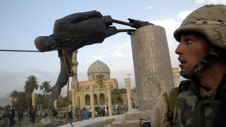 A U.S. soldier watches as a statue of Iraq's President Saddam Hussein falls in central Baghdad, Iraq April 9, 2003.© Goran Tomasevic