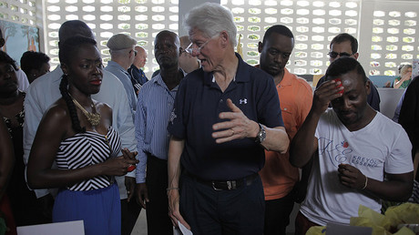 Former U.S. President Bill Clinton (C) chats with staff members during a tour to Kreyol Essence, a Haitian women owned and operated company in Mirebalais February 23, 2015 © Andres Martinez Casares