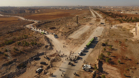 Law enforcement officers near cars and ambulances in a humanitarian corridor along the Castello Road in northern Aleppo, Syria. © Michael Alaeddin