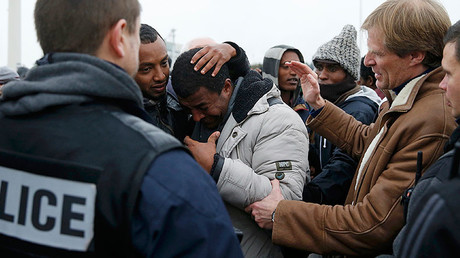Pascal Brice (R), the head of OFPRA, French Office for Refugees and Stateless Persons, comforts an Ethiopian migrant, as he leaves the Calais "Jungle" to be transferred to reception centers, in Calais, France, October 24, 2016. © Pascal Rossignol