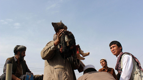 An Afghan man carries the dead body of a child following a NATO coalition airstrike on the outskirts of Kunduz on November 3, 2016. © Bashir Khan Safi