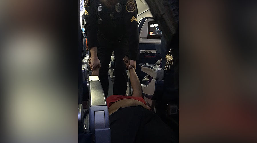 Woman dragged off flight by police for boarding plane too early (VIDEO)