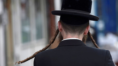 An orthodox Jewish man walks through a street in Stamford Hill north London, Britain. © Hannah McKay