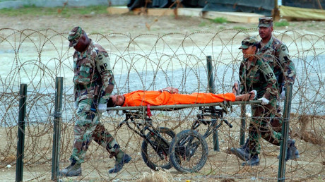A detainee is carried by military police after being interrogated by
officials at Camp X-Ray at the U.S. Naval Base at Guantanamo Bay, Cuba,
Wednesday, Feb. 6, 2002. © Marc Serota