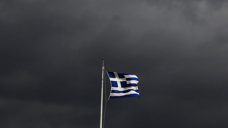 A Greek flag flutters atop the Acropolis hill in Athens © Yannis Behrakis