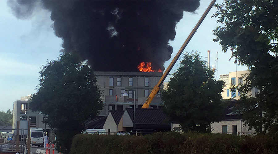 Man escapes burning building by holding on to crane hook (VIDEO)