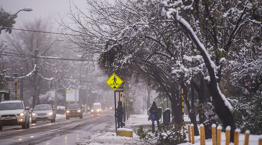 Rare snowstorm batters Chilean capital, leaves one dead & 337k homes without power (PHOTOS)