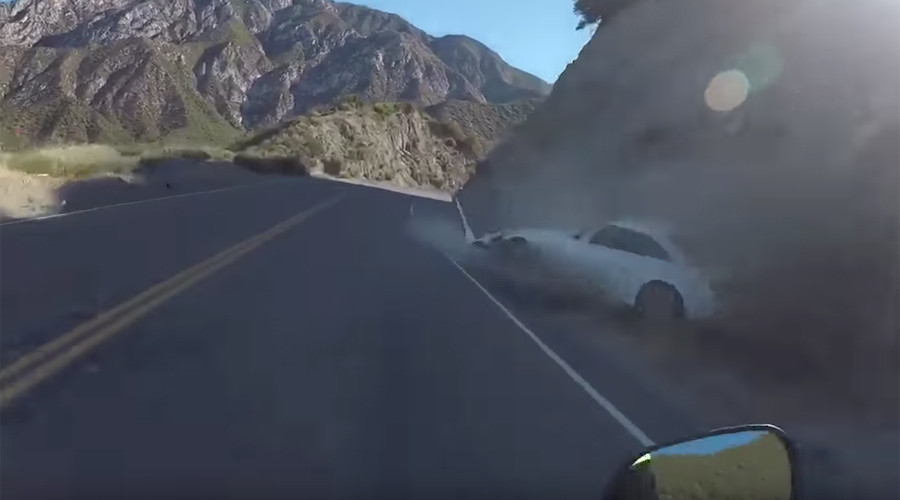 Biker cheats death as runaway roadster careers across highway in horror crash (VIDEOS)