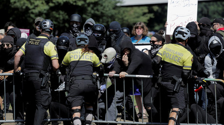 Police officers hold back Antifa protesters at a rally in Portland © Reuters / Elijah Nouvelage 