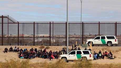 Caravan migrants detained by US Border Patrol at the border fence in El Paso, Texas