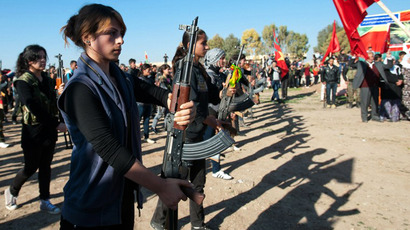 Syrian-Kurdish women stand guard during the funeral of a comrade. (AFP Photo / Giulio Petrocco)