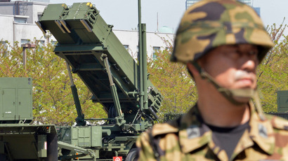 A soldier (R) of Japan's Ground Self Defence Force looks on as Japanese Foreign Minister Fumio Kishida (unseen in this picture) inspected Patriot Advanced Capability-3 (PAC-3) missile launchers at the Defence Ministry headquarters in Tokyo on April 13, 2013 (AFP Photo / Yoshikazu Tsuno)