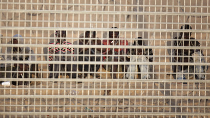 A group of about 20 African migrants behind the border fence on the Israel-Egyptian border, near the Israeli village of Be'er Milka in the south (AFP Photo / Menahem Kahana)