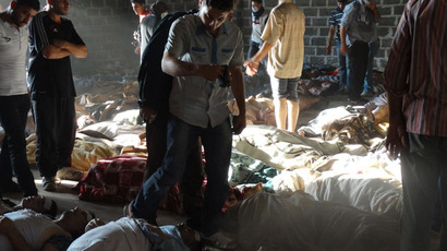 A handout image released by the Syrian opposition's Shaam News Network shows people inspecting bodies of children and adults laying on the ground as Syrian rebels claim they were killed in a toxic gas attack by pro-government forces in eastern Ghouta, on the outskirts of Damascus on August 21, 2013. (AFP Photo/Shaam News Network)