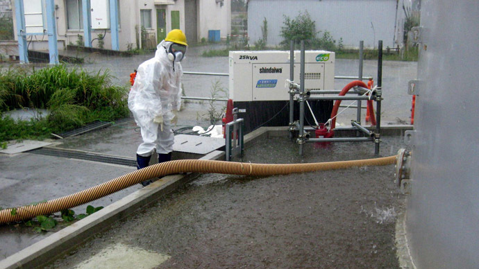 This handout picture taken by Tokyo Electric Power Co. (TEPCO) on September 15, 2013 and released on September 17 shows a TEPCO worker pumping rainwater around the contamination water tank at TEPCO's Fukushima dai-ichi nuclear plant at Okuma town in Fukushima prefecture. (AFP Photo/TEPCO)
