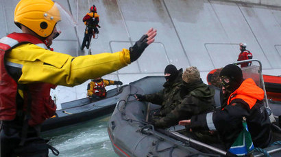 Inflatable boat with officers of Russian Coast Guard aboard (R) aproaching Greenpeace International activists during their attempt to climb Gazprom’s ‘Prirazlomnaya’ Arctic oil platform somewhere off Russia north-eastern coast in the Pechora Sea.(AFP Photo / Denis Sinyakov)