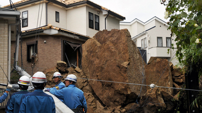 A house and an electric pole smashed by large rocks from a collapsed slope caused by heavy rain in Kamakura, suburban Tokyo on October 16, 2013 (AFP Photo / Jiji Press)