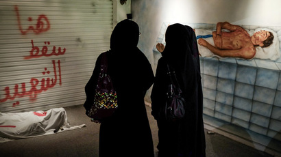 Bahraini women stand in front of an art installation at the "revolution museum" on October 28, 2013 in Manama. (AFP Photo)